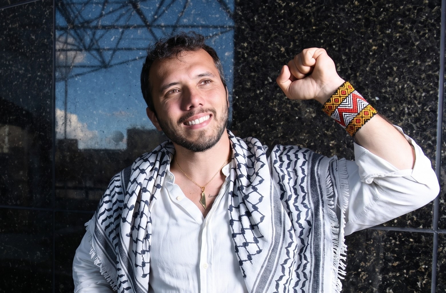 Thiago Ávila com keffiyeh palestina e punho erguido